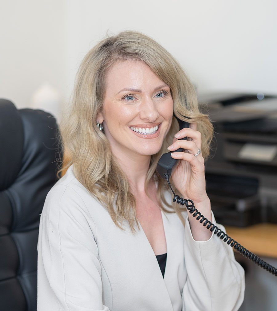 Friendly receptionist smiling behind the desk at Smileworks Brighton dental practice
